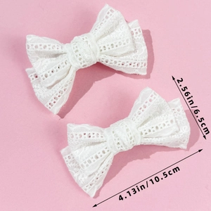 Detailed view of two white lace bow hair clips with size measurements on pink backdrop
