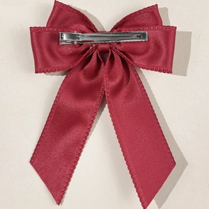 Close-up of red satin bow hair clip with scallop lace edge and silver metal duckbill clip