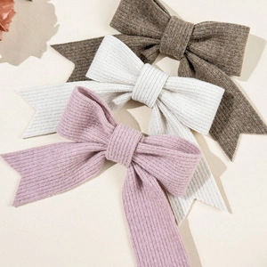 Three-pack of knitted ribbon bow hair clips in brown, white and pink for autumn fashion