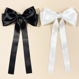 Détail des nœuds à cheveux élégants en satin noir et blanc avec de longs rubans fluides