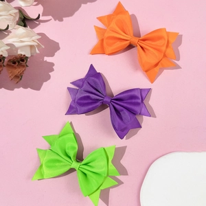 Tre fermagli per capelli con fiocchi colorati in arancione, viola e verde per bambine