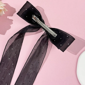 Vue détaillée d'un nœud papillon en maille noire avec strass brillants et pince en métal