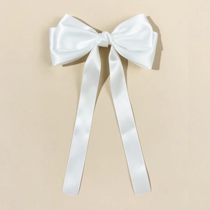 Gros plan d'un nœud papillon en satin blanc avec longs rubans pour cheveux élégant