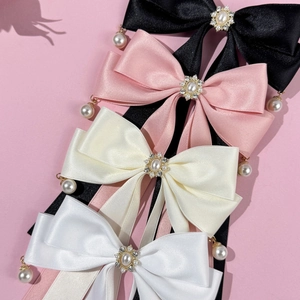 Details von vier Satin-Schleifen-Haarspangen in Schwarz, Rosa, Beige und Weiß mit Perlen