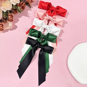 Elegant satin bow hair clips with long ribbons in five colors on a pink background