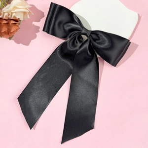 Grande pince à cheveux élégante en satin noir avec longs rubans sur un présentoir