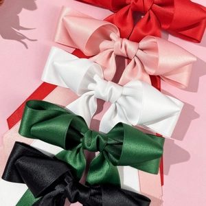 Detail of assorted satin bow hair clips with long streamers in various elegant colors