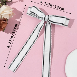 Top view of long white ribbon bow hair clip with houndstooth edge and size measurements