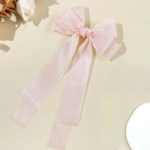 Eleganter hellrosa Chiffon-Bogen-Haarclip mit langen Bändern auf beige Hintergrund