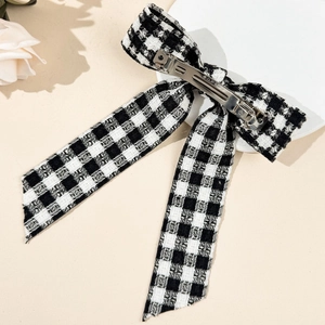 Barrette à nœud en motif pied-de-poule avec rubans sur un fond minimaliste