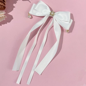 Details der weißen Satin-Haarschleife mit Perleneinlage und langen Bändern