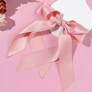 Detailed view of the pink satin ribbon hair clip with elegant flowing streamers