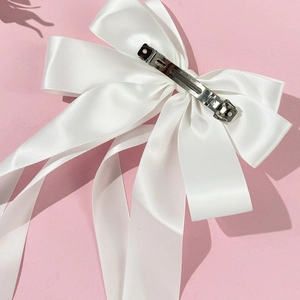 Detailansicht der großen weißen Satin-Schleife Haarspange mit langen Bändern und Metallclip