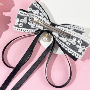 Elegant black ribbon hair clip with white floral lace layers and hanging faux pearl charm