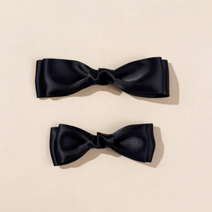 Detailed view of two black satin double-layer bow hair clips in large and small sizes