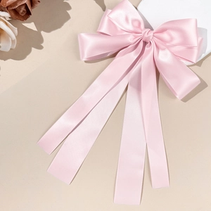 Eleganter großer rosa Satin-Bogen Haarclip mit langen Bändern auf schlichtem Hintergrund
