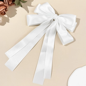 Eleganter weißer Satin-Haarclip mit großer Schleife und langen Bändern auf beigem Grund