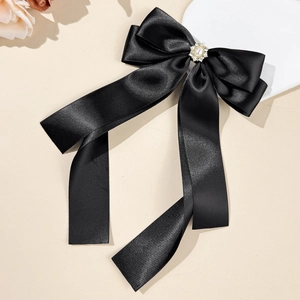 Detail of elegant black satin bow hair clip with pearl and rhinestone embellishments