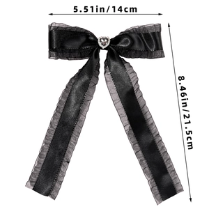 Detailed view of black satin bow hair clip with grey lace edge and heart gemstone decoration