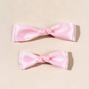 Set of two sweet pink satin double-layered bow hair clips for women in a vertical flat lay