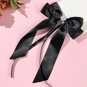 Elegante fermaglio per capelli in raso nero con perle su uno sfondo rosa