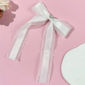 White satin ribbon hair clip with double-layer ruffles and a heart rhinestone detail