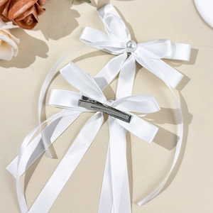 Détail de barrettes à cheveux en satin blanc avec perles et pince crocodile en métal