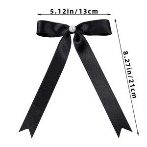 Detail of elegant black satin bow hair clip with white pearl and 21cm long streamers
