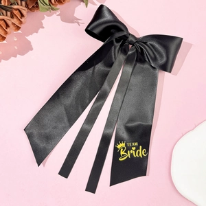Detail der schwarzen Satinschleife mit gelber Team Bride Aufschrift und langen Bändern