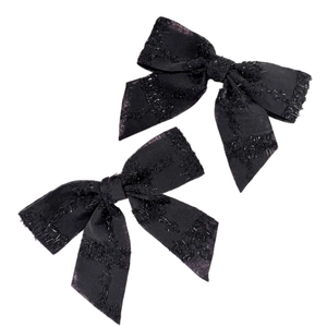 Paio di graziose mollette a fiocco nero con texture glitterata e code in nastro