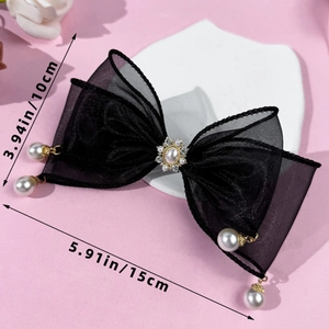 Détail d'une pince à cheveux nœud en résille noire avec perles et strass sur rose