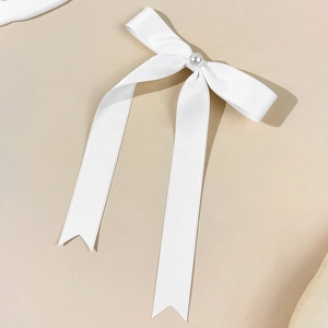 Elegant white satin bow hair clip with pearl accent and long flowing ribbons