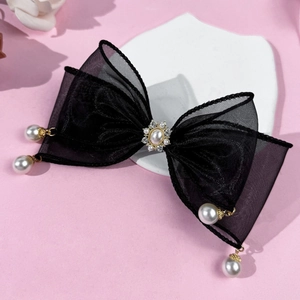 Détail de la pince à cheveux noeud en tulle noir avec strass et perles suspendues