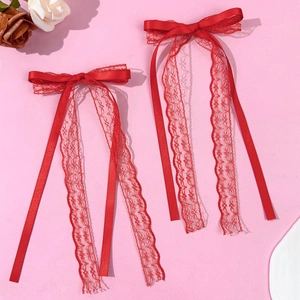 Detailed view of red ballet style lace bow hair clips with long elegant ribbons