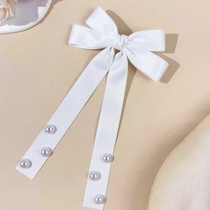 Pince à cheveux élégante en satin blanc avec rubans et perles sur fond neutre