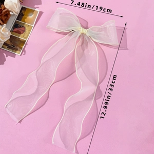 Detail showing the dimensions of the oversized beige mesh bow hair clip with wavy ribbons