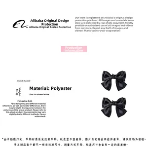 Detailed view of black satin bow hair clips showing double-layered polyester fabric texture