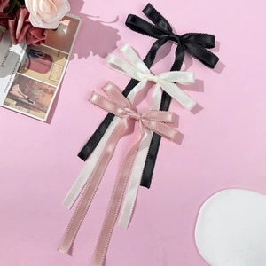 Trois pinces à cheveux élégantes avec longs glands en noir, blanc et rose