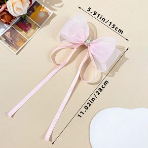 Dettaglio del fiocco in tulle rosa chiaro con perle e lunghi nastri da 28cm di lunghezza