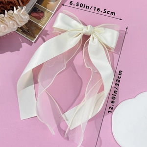 Detail of elegant cream ribbon and organza bow clip measuring 6.5 by 12.6 inches