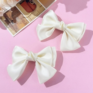 Pair of cream satin bow hair clips for women with elegant double-layered ribbon design