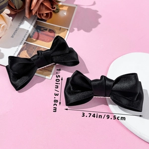 Detailaufnahme der schwarzen Satin-Schleifen-Haarspangen mit Maßen 9.5cm x 3.8cm