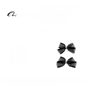 Détail de barrettes à nœuds en résille noire avec centre orné de strass brillants