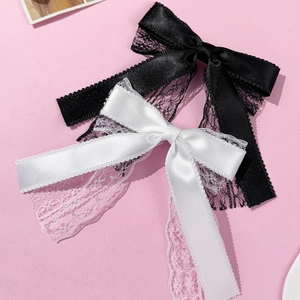 Elegant black and white lace bow hair clips with silky satin ribbons on pink background