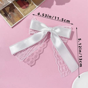 Detailed size view of a white lace bow hair clip measuring 11.5cm by 13cm on pink background