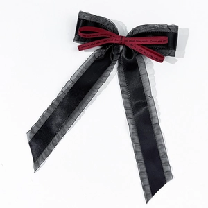 Detailansicht Haarklammer mit schwarzer Netzspitze und rotem Band mit elegantem Druck