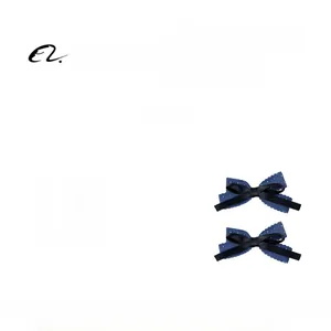 Detail view of navy blue ribbon bow hair clips with polka dot texture and layered design