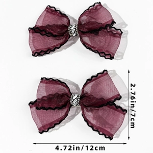 Détail de barrettes à nœud en résille bordeaux avec bordure en dentelle et strass