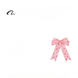 Detail of pink bow hair clip with heart print and long ribbon streamers for women
