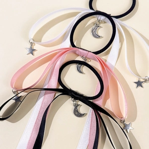 Detail of satin ribbon hair ties with moon and star metal charms in black white and pink